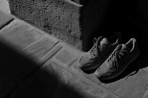 A pair of sneakers resting on a stone surface. photo