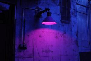 A purple-lit industrial wall with a lamp fixture. photo