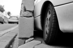 Car closely parked next to a concrete barrier. photo