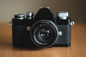Classic camera with a lens on a wooden surface. photo