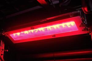 Bright red light panel under machinery. photo