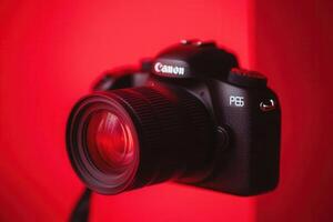 Camera with a red backdrop, highlighting photography gear. photo
