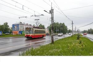 City street with trolleybus and vehicles on a rainy day. photo