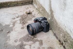 Camera resting on a surface near a wall. photo