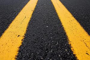 Close-up of a road surface with yellow lane markings. photo