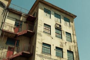 Abandoned building with weathered exterior and fire escape. photo