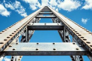 A tall metal ladder reaching towards a blue sky. photo