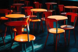 Brightly colored chairs and tables in a dim setting. photo