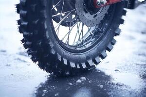 Close-up of a dirt bike tire on wet ground. photo