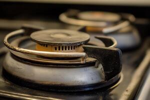 Close-up of a gas stove burner, showing wear and use. photo