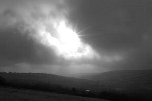 Dramatic clouds with sunlight breaking through in landscape. photo