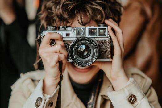 Person smiling while holding a vintage camera. photo