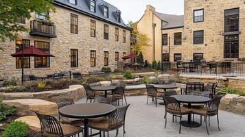 A courtyard with tables and chairs in front of a building photo