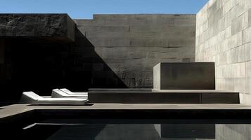 A pair of lounge chairs sit in front of a pool photo