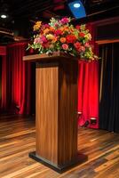 Wooden podium with floral arrangement on stage photo