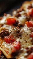 Close Up of a Delicious Meat Pizza with Melted Cheese and Tomatoes photo