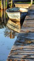 Vintage Wooden Boat Docked at a Tranquil Pier photo