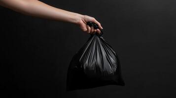 Hand Holding a Black Trash Bag - Environmental Responsibility photo