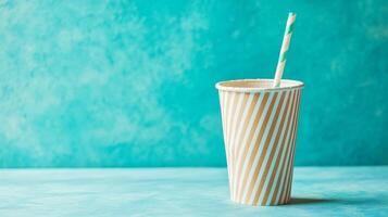 Striped Paper Cup with Straw on Turquoise Background photo