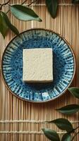 A Square Block of Tofu on a Blue Plate, a Simple and Healthy Dish photo