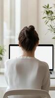 Woman Focused on Work on Laptop, Modern Office Setting photo