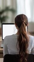 Woman Concentrating on Laptop, Back View photo