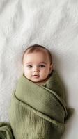 Precious Newborn Baby Wrapped in a Soft Green Blanket photo