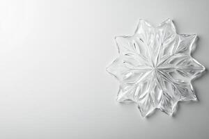 Glass snowflake decor with intricate design on white surface photo