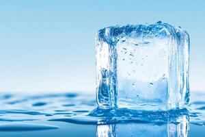 Clear ice block with water droplets on blue photo
