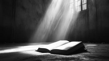 Open book illuminated by sunlight in dark stone room photo