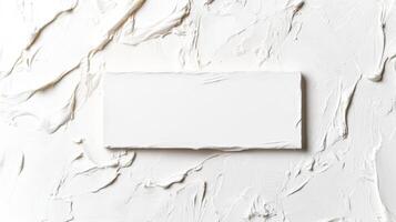 White torn paper rectangle on textured surface photo