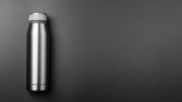 Stainless steel thermos flask on dark backdrop photo
