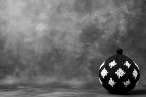 Knitted ball with diamond pattern on grey backdrop photo