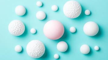 White and Pink Spheres of Various Textures on Turquoise Background photo