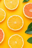 Citrus Fruit Halves with Leaves on Bright Yellow Background photo