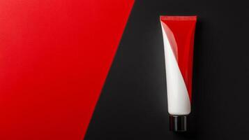 Bold Red and White Tube of Cream on Geometric Black and Red Surface photo