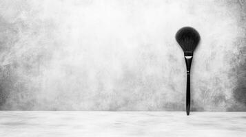 Minimalist Black and White Makeup Brush on Textured Gray Background photo