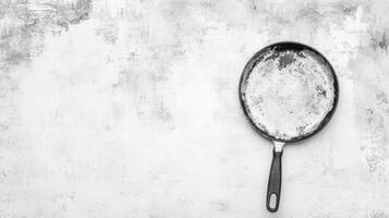 Used Cast Iron Skillet on Textured Grey Background in Monochrome photo