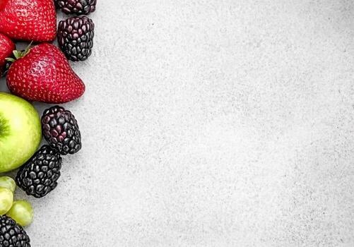 Assorted Fresh Fruits Border Frame with Strawberries Blackberries and Green Apple photo