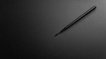 Simple Black Cosmetic Eyeliner Applicator on Plain Dark Surface photo