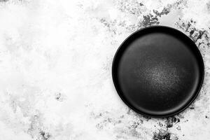 Empty Black Ceramic Plate on Textured Gray Background photo