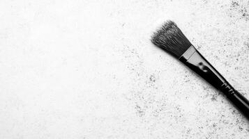 Elegant Makeup Brush on Speckled White Background photo
