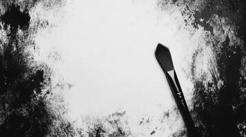 Artistic Brush Resting on a Canvas with Bold Black and White Strokes photo