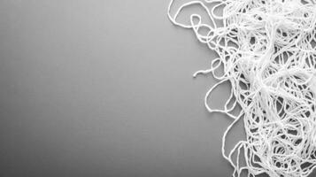 White threads randomly scattered on a gray background photo