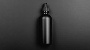 Sleek matte black glass bottle with dropper on dark surface photo