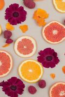 Vibrant Citrus Slices and Deep Red Flowers Create a Colorful Pattern photo
