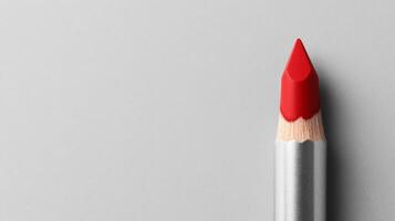 A Red Tipped Pencil Point on a Plain Gray Background photo