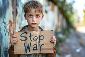 A young Caucasian boy holds a cardboard sign reading 'Stop War', expressing a powerful message against violence. photo