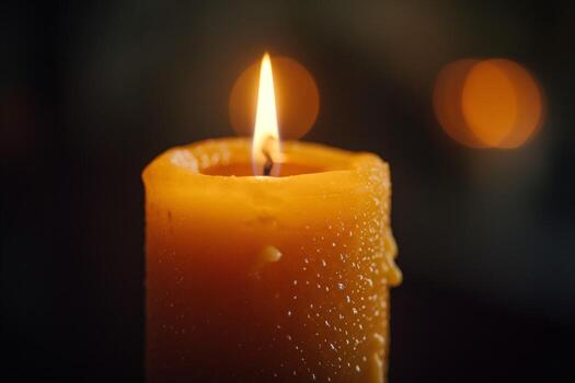 Close-up of a glowing orange candle, with soft focus background lights creating a warm ambiance. photo