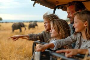 A joyful father and his three daughters explore wildlife, pointing excitedly at elephants in the distance. photo
